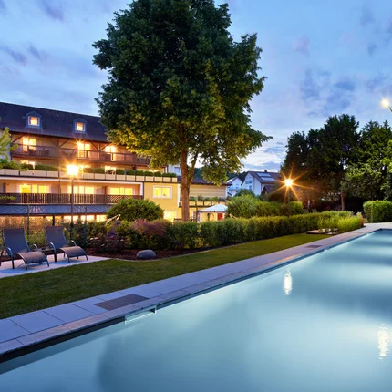 Garden & Spa Hotel das Götzfried © Michael Huber Fotographie Verlichte buitenzwembad en tuin van een hotel bij schemering
