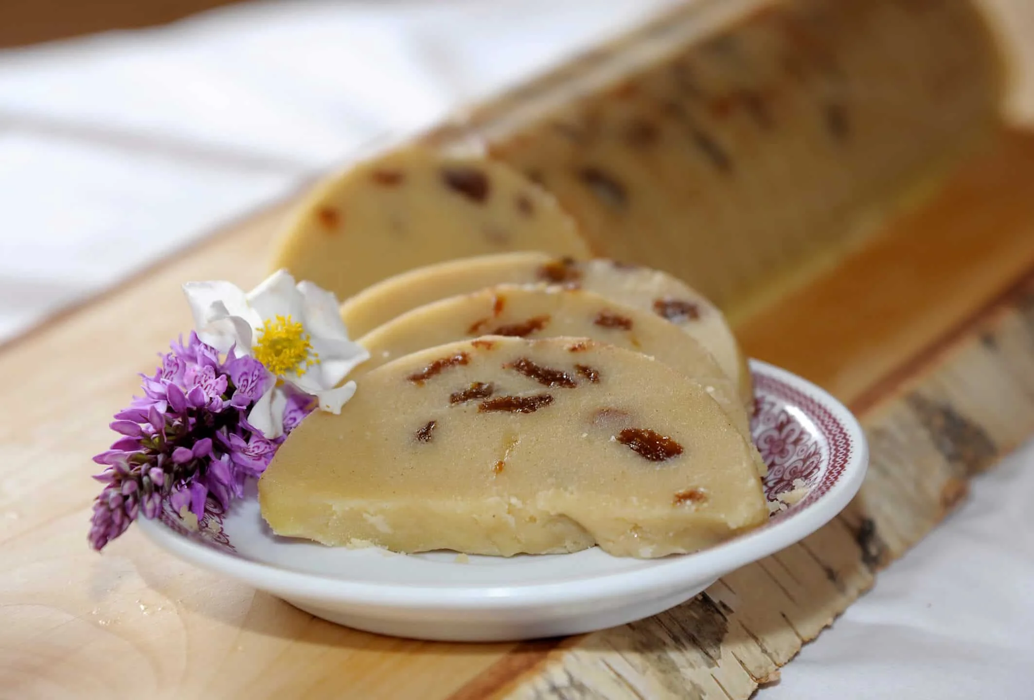 Plakjes zoet griesmeel dessert met rozijnen op een bord met bloemen