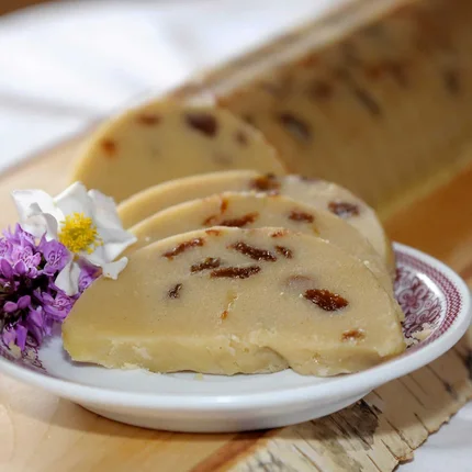 Plakjes zoet griesmeel dessert met rozijnen op een bord met bloemen