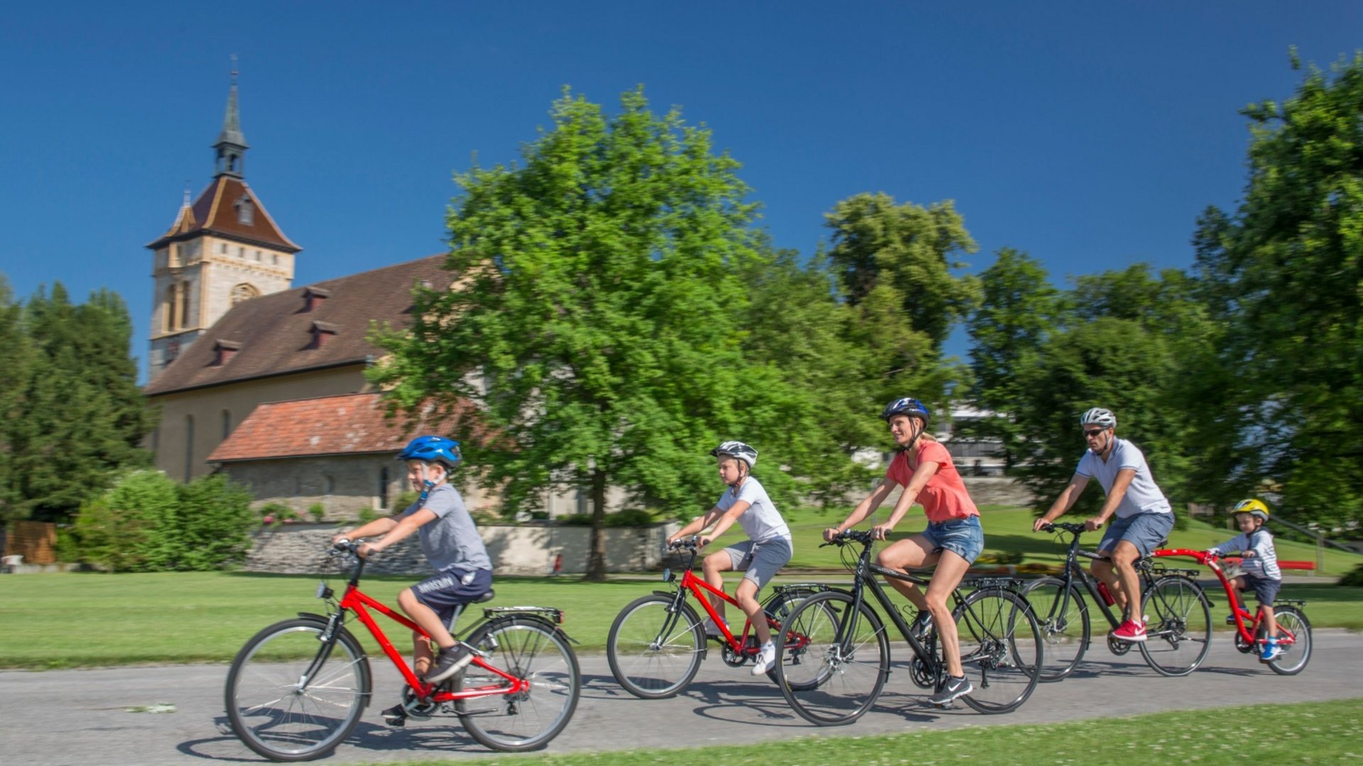 Family with children cycling on a bike path on a sunny day