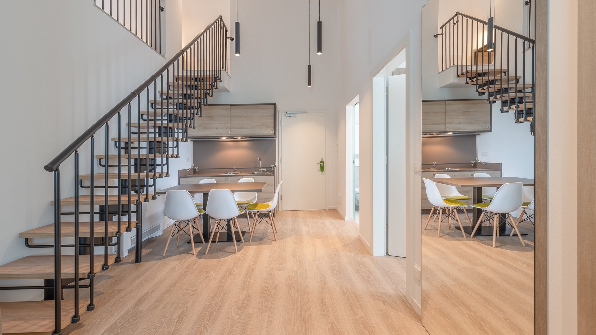 Modern open living area with staircase and dining table