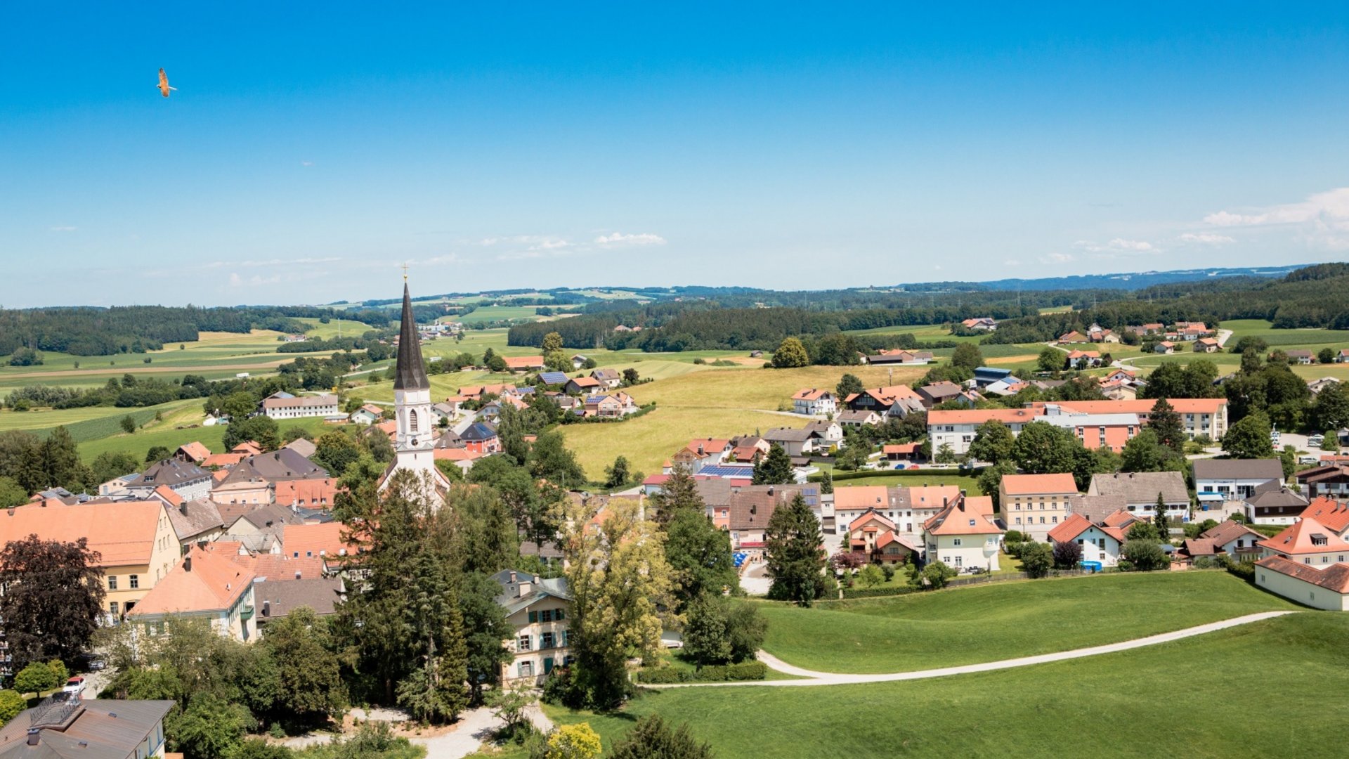 View of a village with a church in the countryside under clear skies
