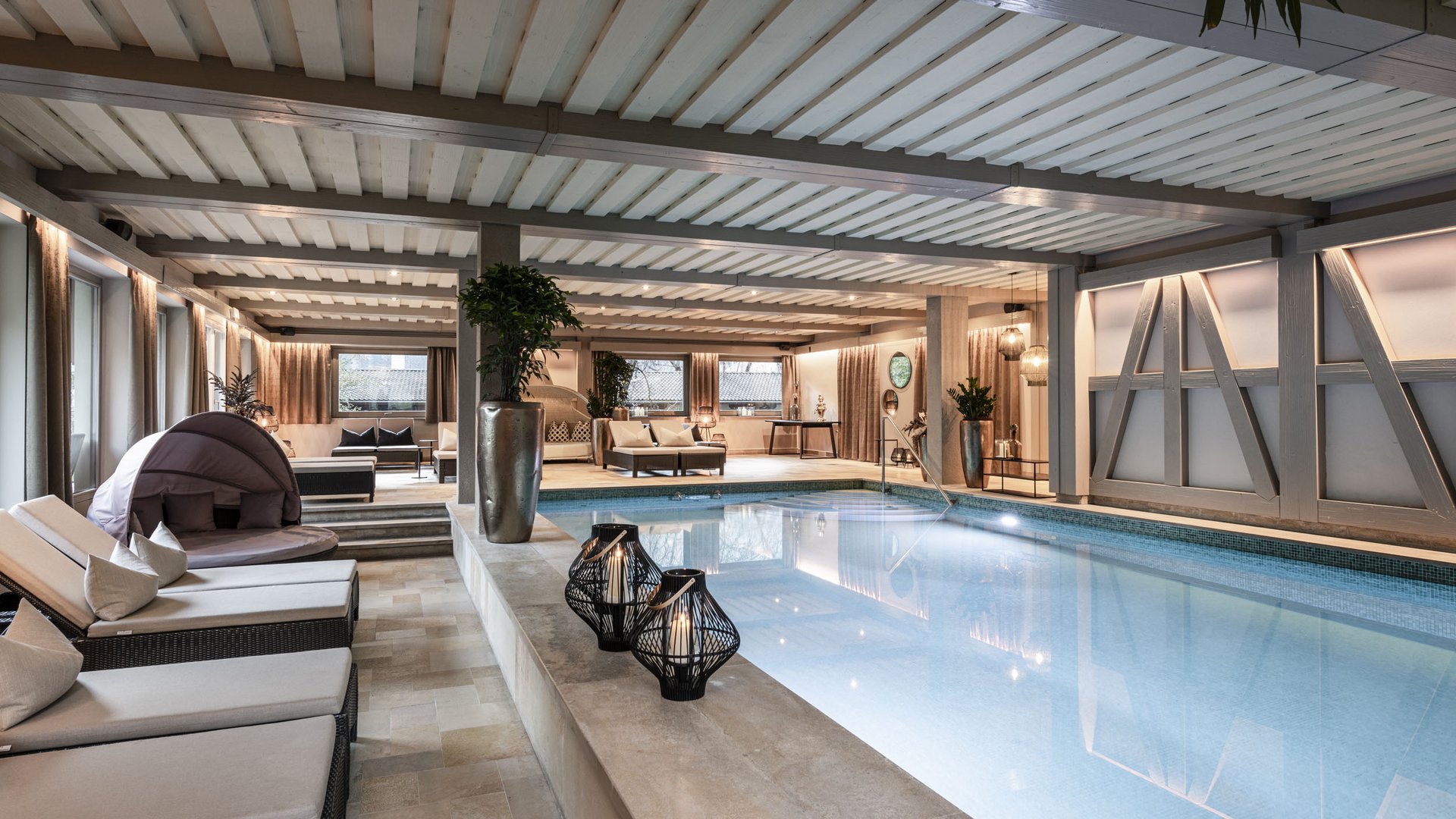 Luxury indoor pool with lounge seating and modern lighting