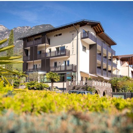Hotel Winzerhof with mountain backdrop and lush garden