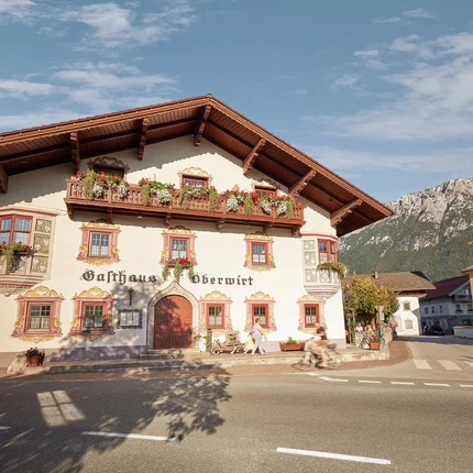 Gasthaus-Hotel Oberwirt © Julian Höck Traditioneel gastenhuis met bloemen op ramen en balkon in berglandschap