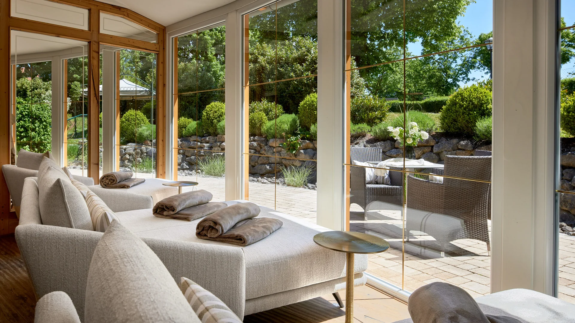 Garden & Spa Hotel das Götzfried **** © Michael Huber Fotographie Lichte ligstoelen met handdoeken bij grote ramen met uitzicht op tuin