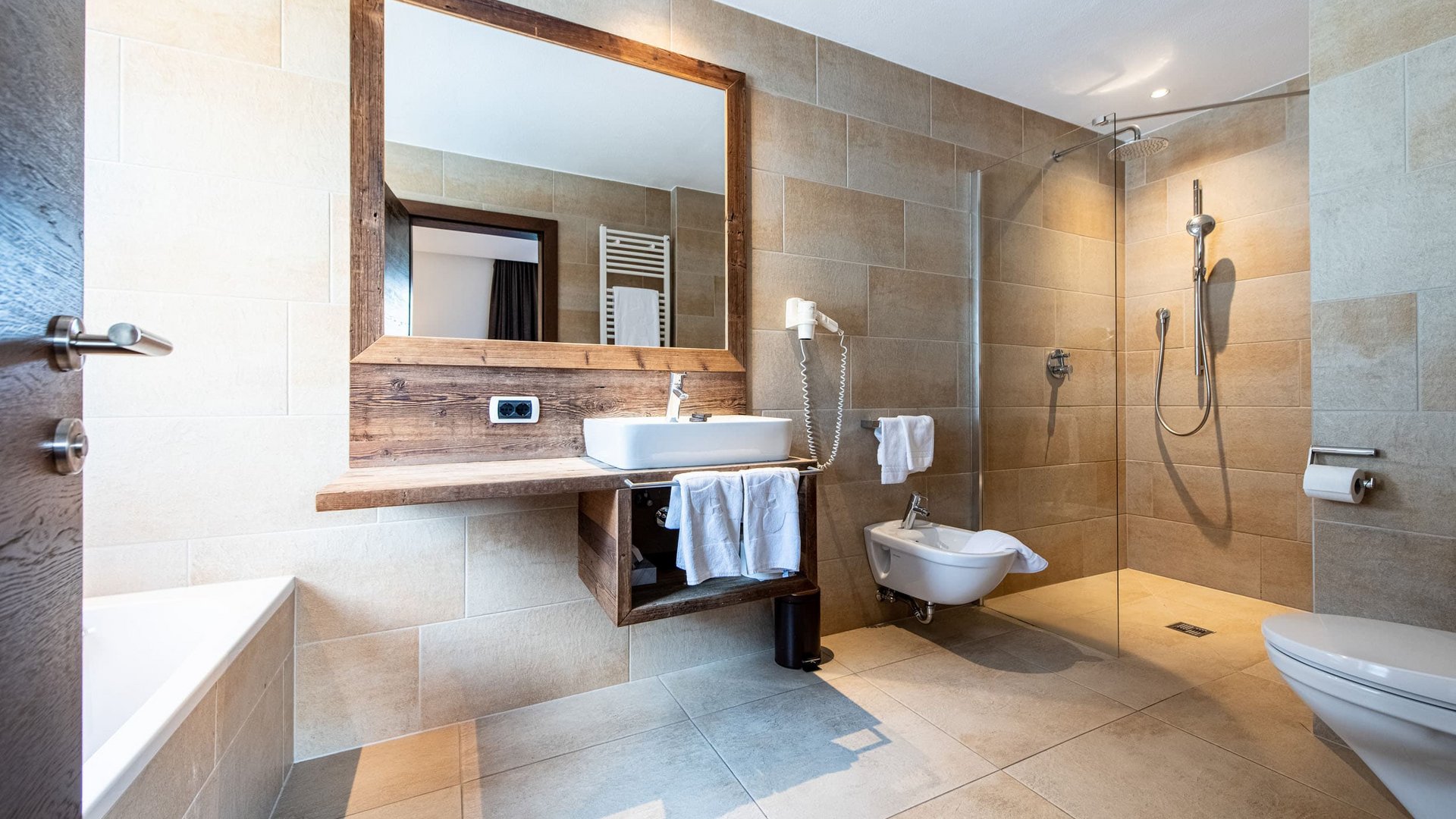 Modern bathroom with wooden mirror frame, sink, and walk-in shower