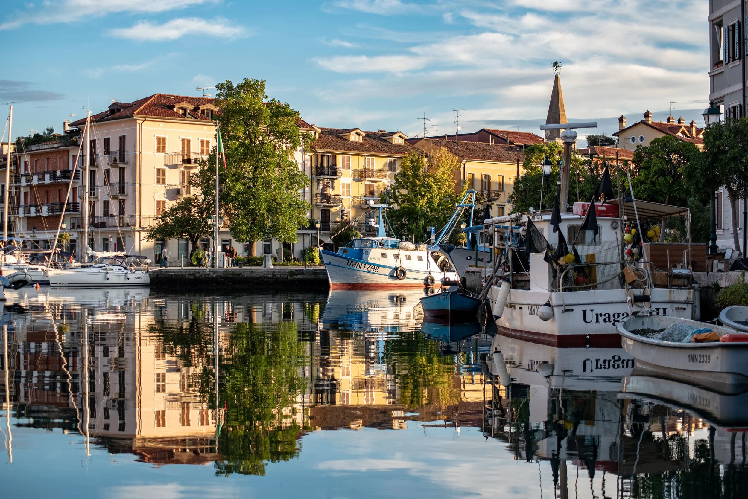 Boote am Kanal mit Gebäuden und Bäumen, Spiegelung im Wasser