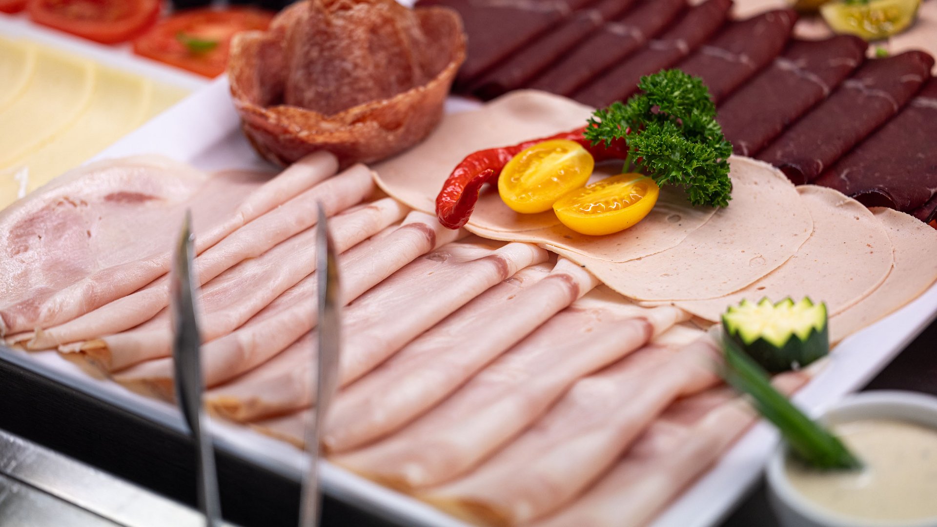 Assorted thinly sliced deli meats arranged on a platter