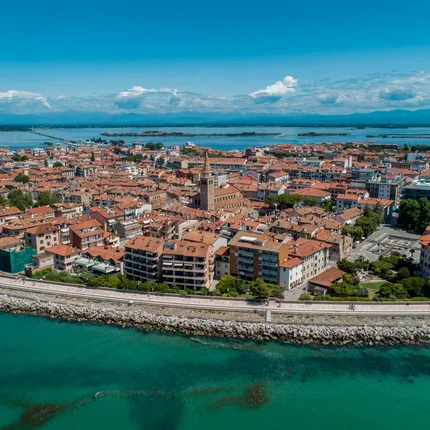 Luchtfoto van een kuststad met rode daken en helder blauw water
