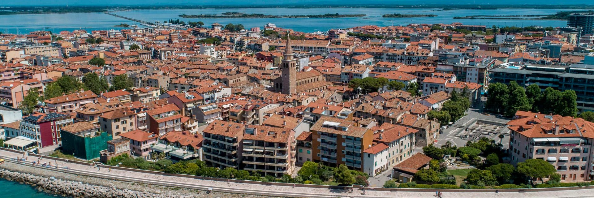Aerial view of a coastal town with red roofs and clear blue water