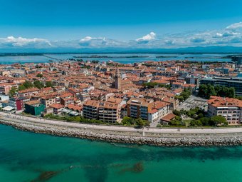 Aerial view of a coastal town with red roofs and clear blue water