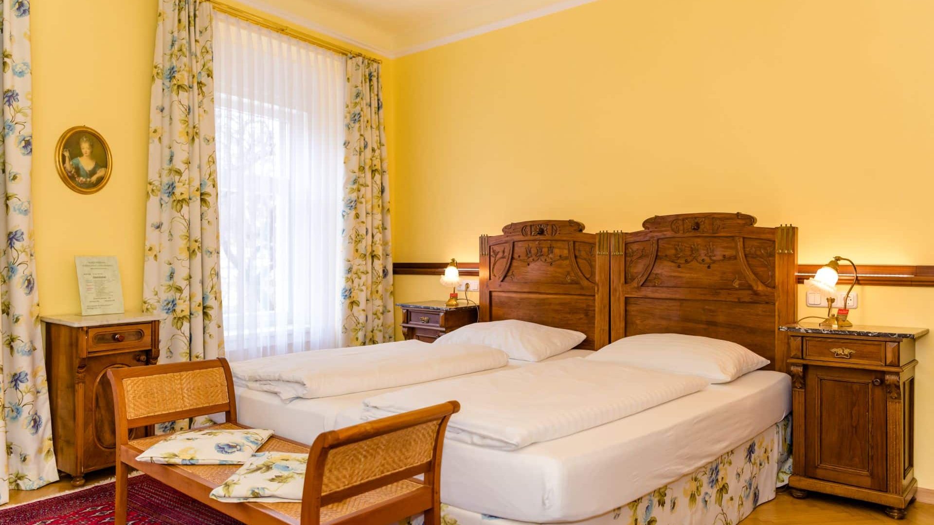 Cozy double room with wooden furniture and yellow walls