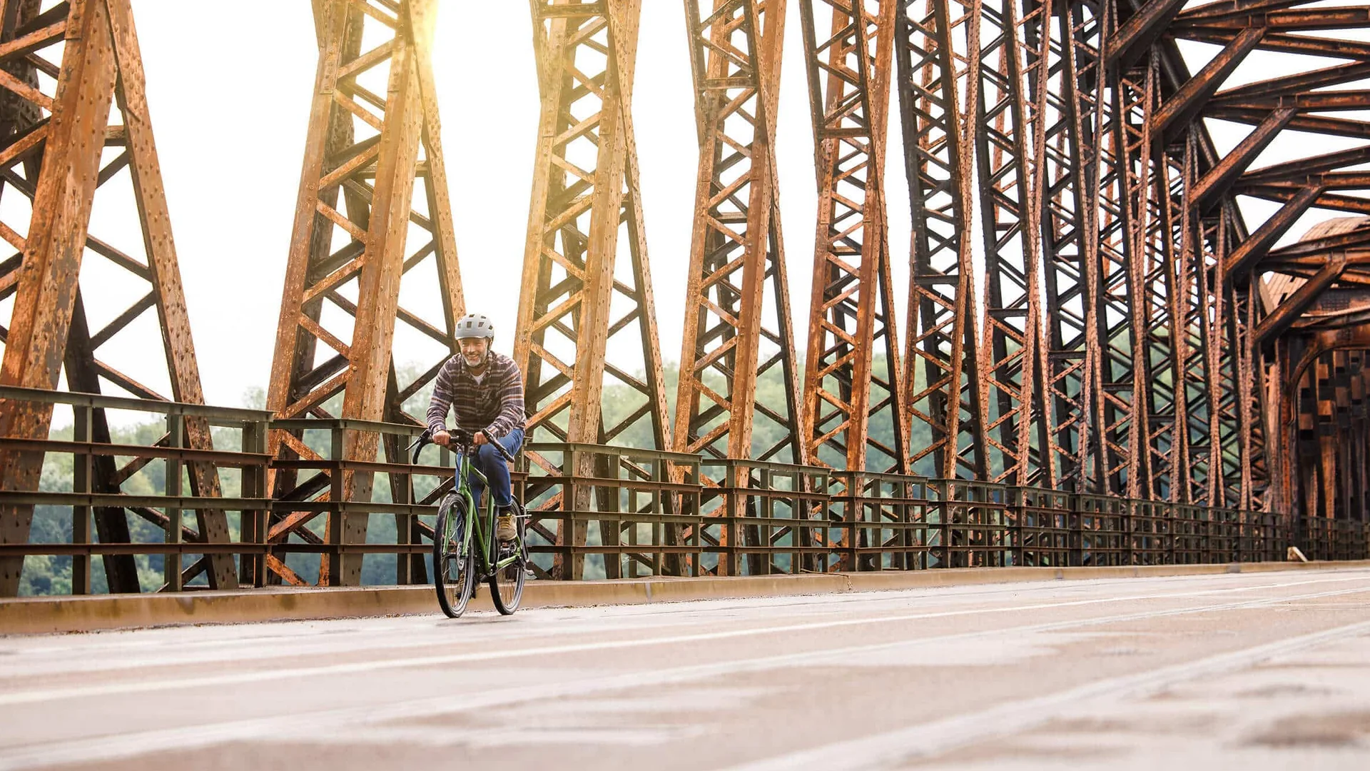 Schwalbe © Ralf Bohle GmbH Man fietst op roestige stalen brug met zonlicht