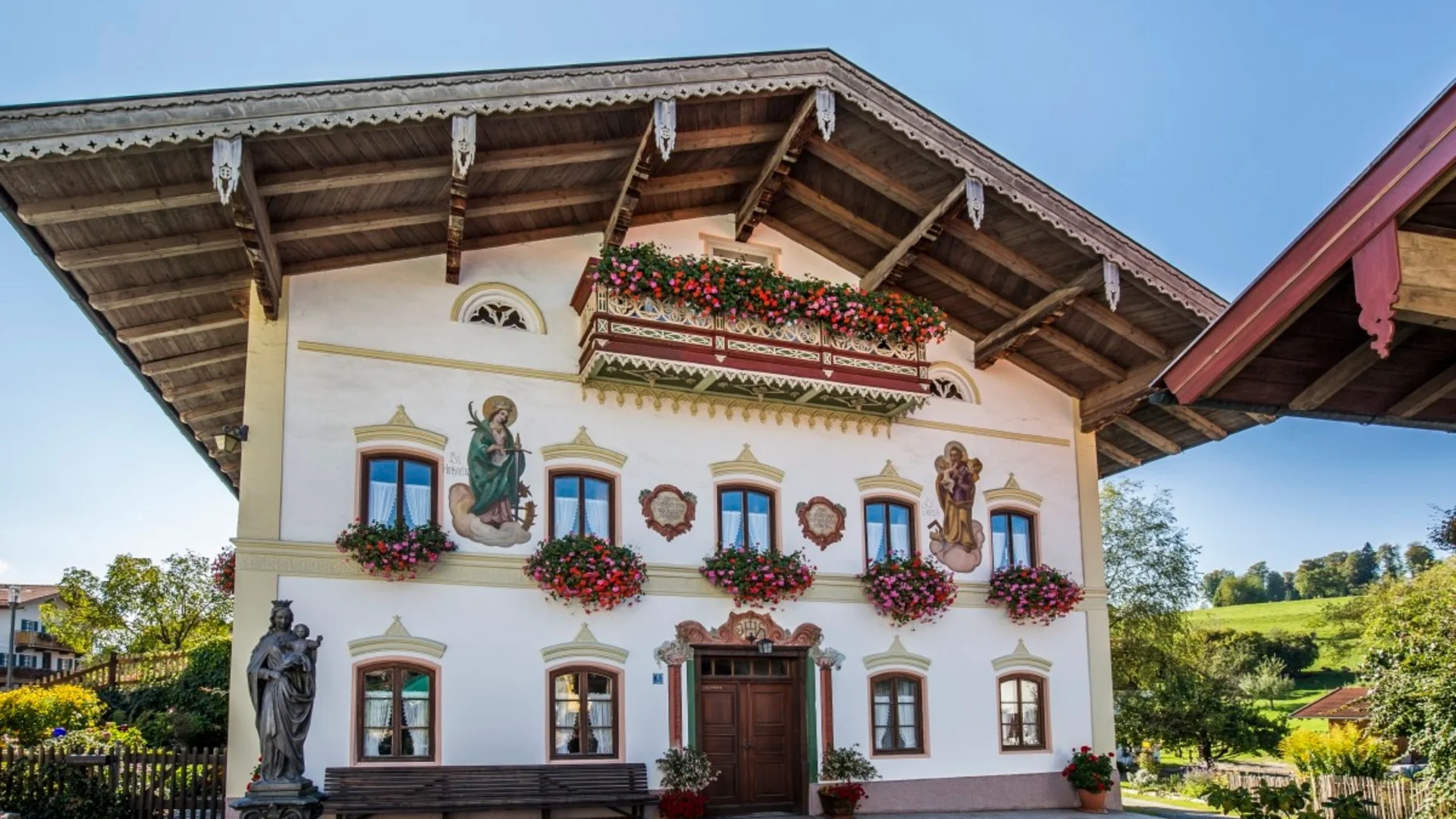 Traditionelles Haus mit bemalten Wänden und Blumen im bayerischen Stil
