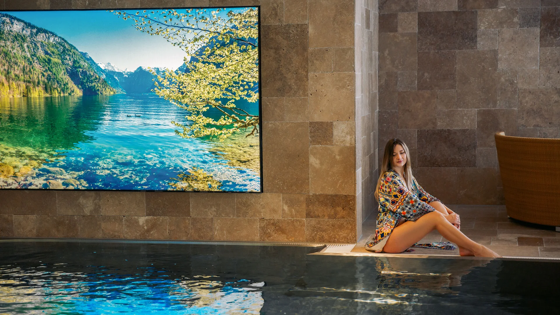 Hotel Thierseerhof **** Woman sitting relaxed next to indoor pool with mountain lake picture on wall