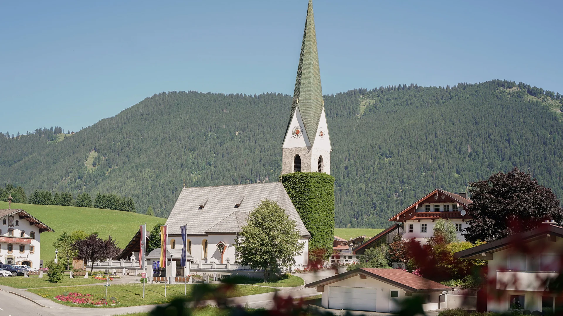 Hotel Thierseerhof **** © Florian Fechter Church with pointed steeple and mountains in the background in a village