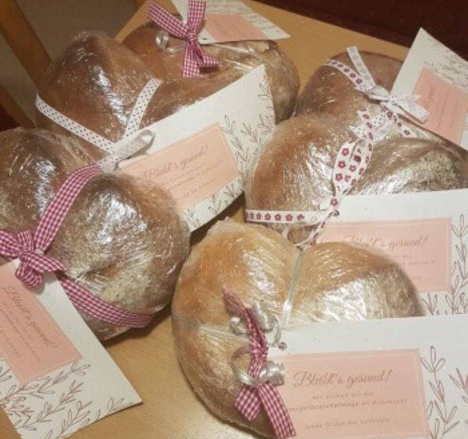 Several heart-shaped breads wrapped with ribbons and greeting cards on a table