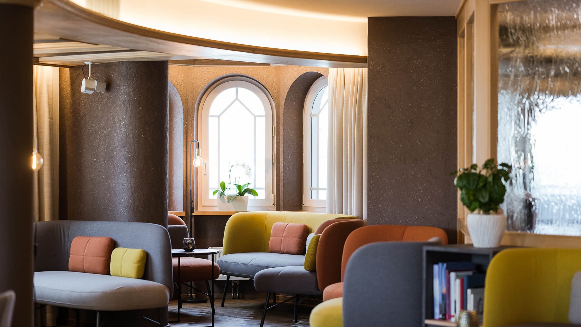 Modern lounge with colorful sofas and rounded windows