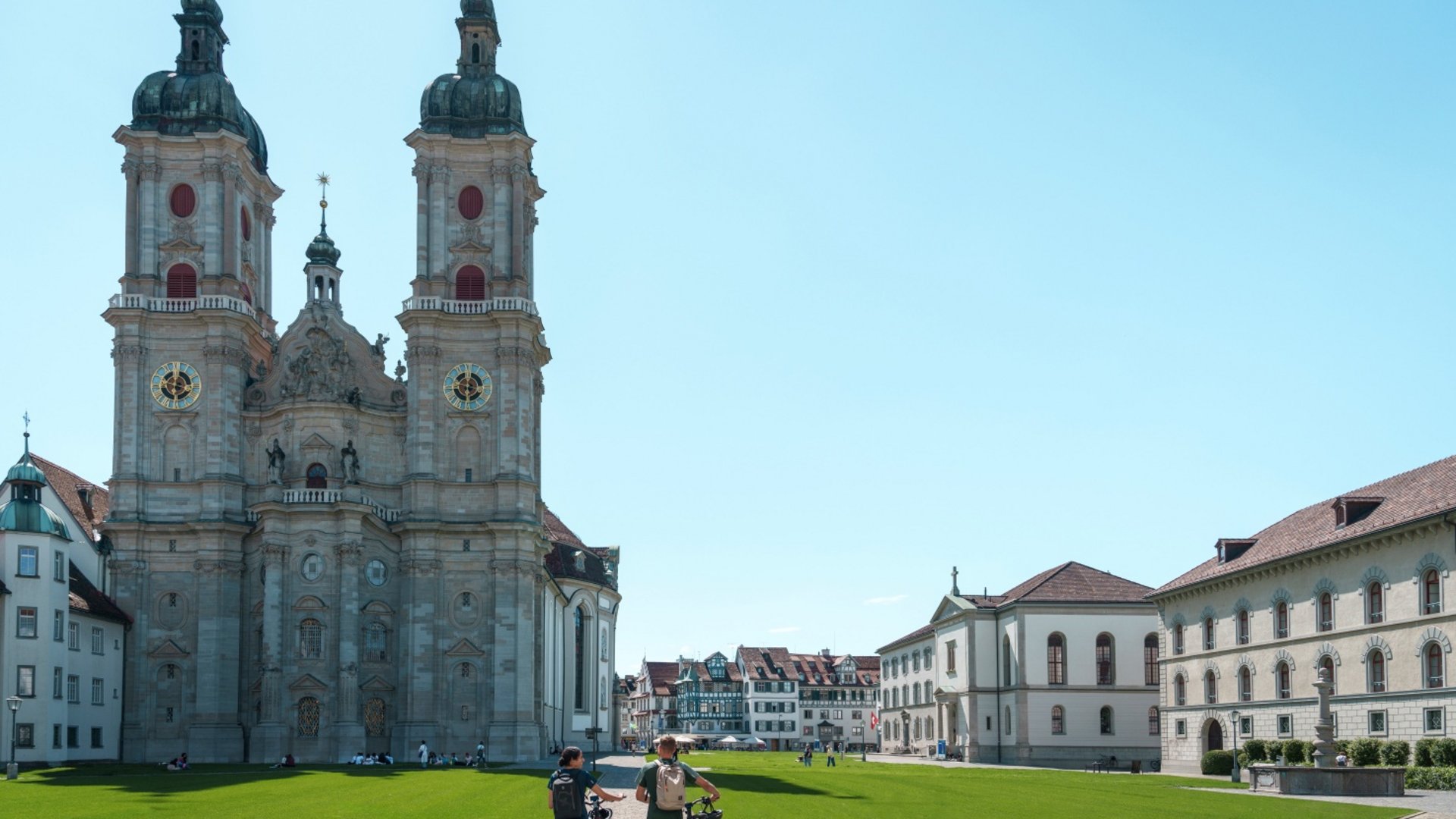 Two cyclists walking with bikes near Abbey Cathedral of St. Gallen