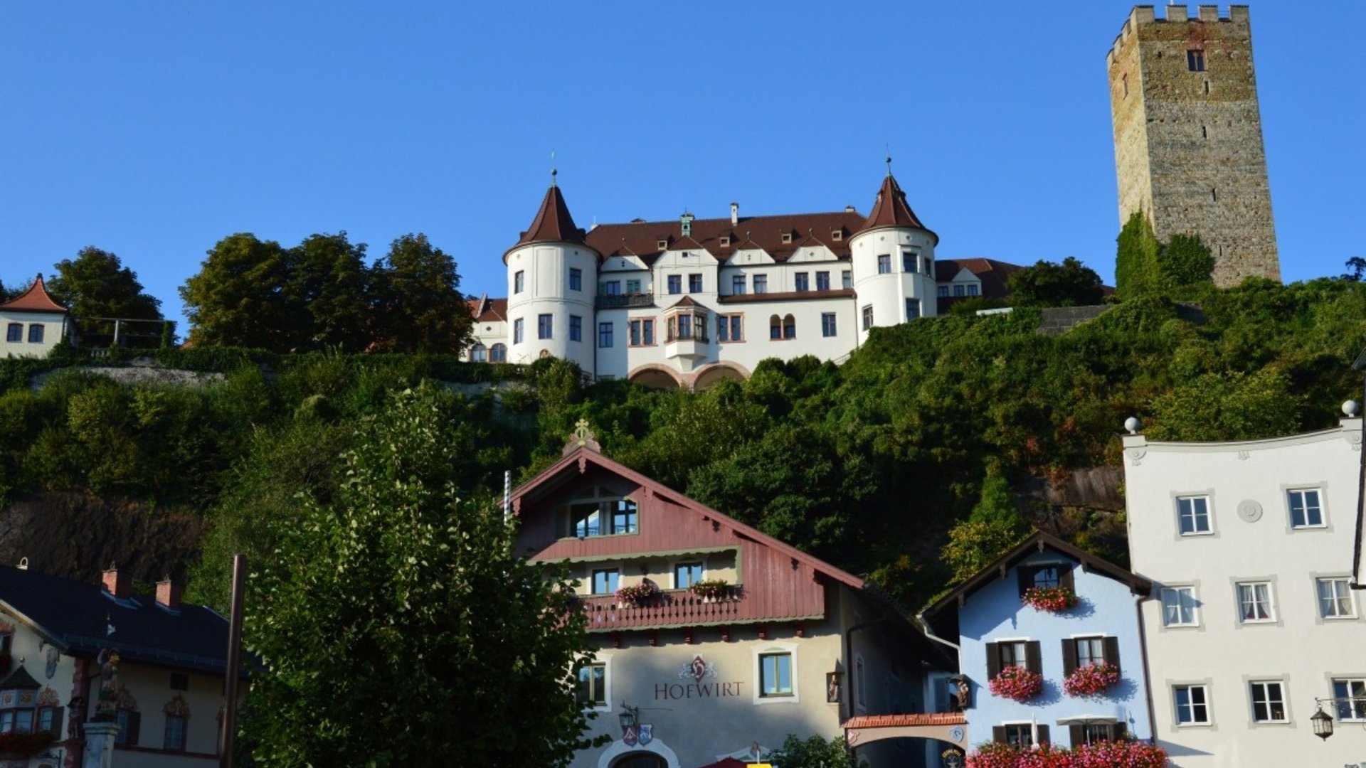 Historic castle on hill with classic architecture and colorful houses below