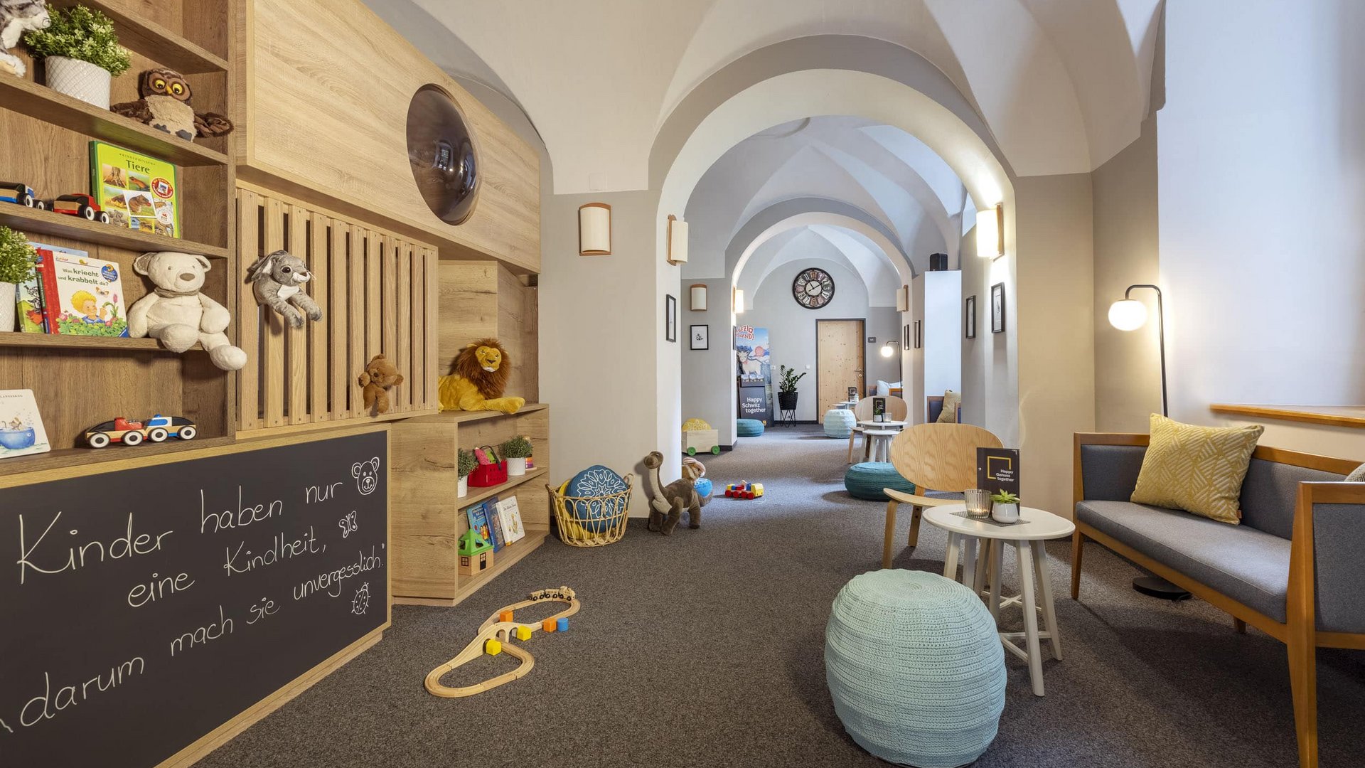 Bright hallway with toys, seating, and decorative wall shelves