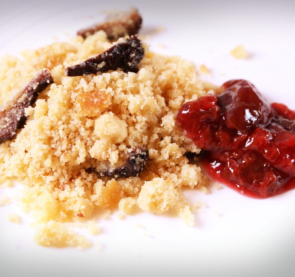 Crumble cake with fruit jam on white plate