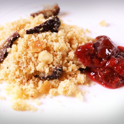 Crumble cake with fruit jam on white plate