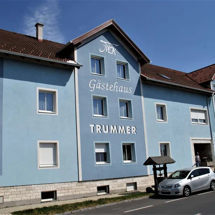 Blaues Gästehaus Trummer mit Autos davor unter blauem Himmel