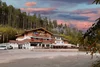 Collective enquiries Hotel with terrace near forest under colorful evening sky