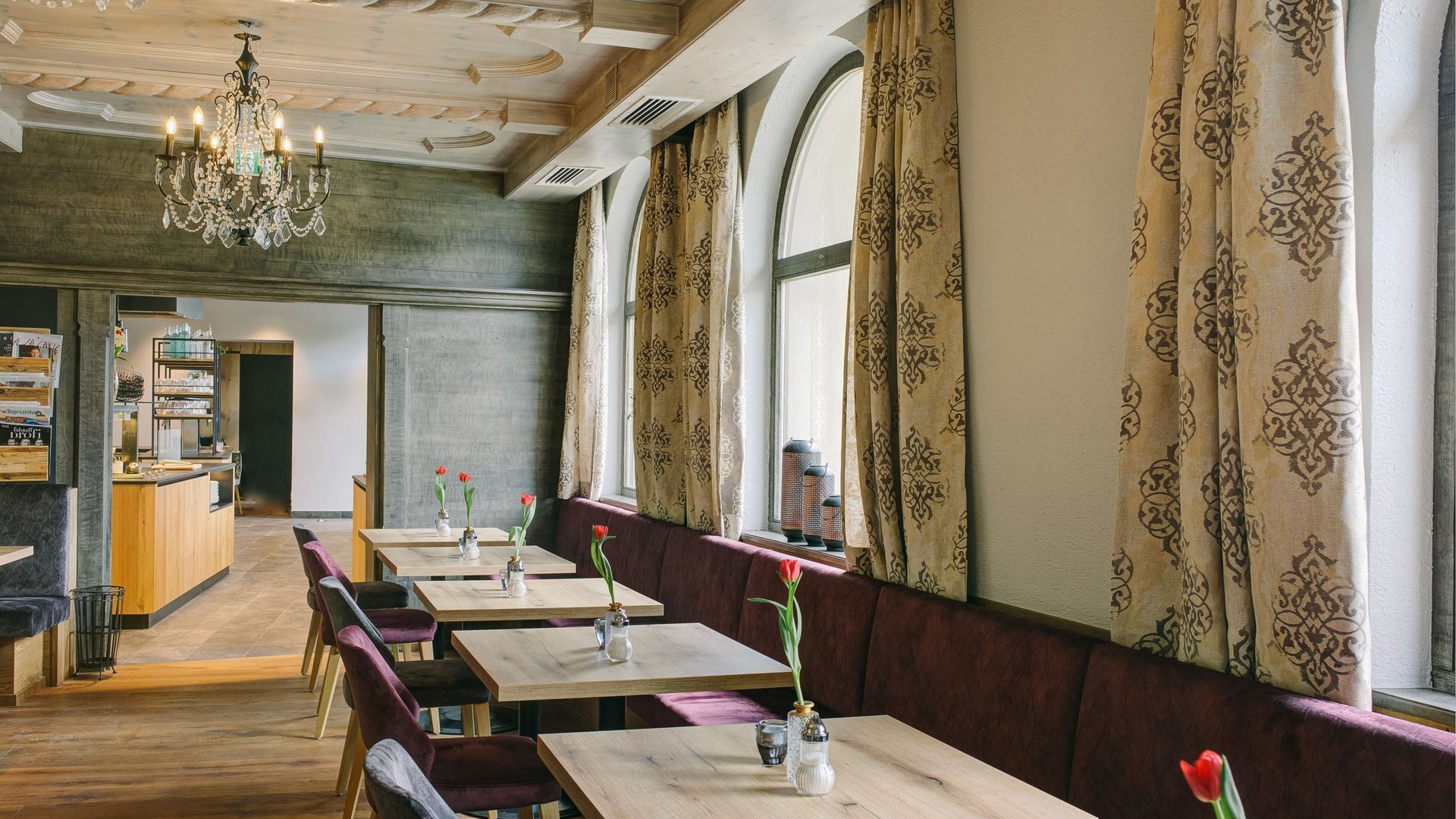 Interior of a café with tables, chairs, and decorative curtains