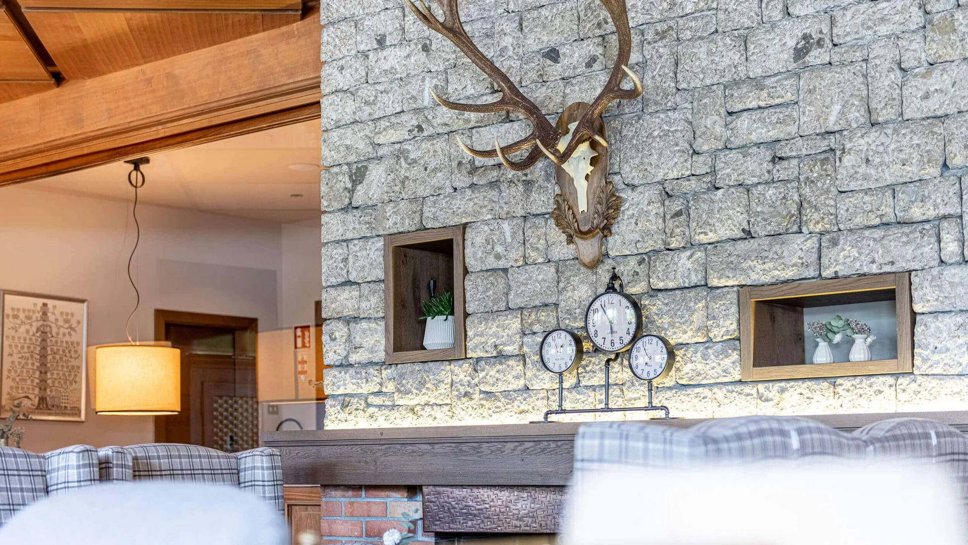 Cozy room with stone wall and mounted deer antlers