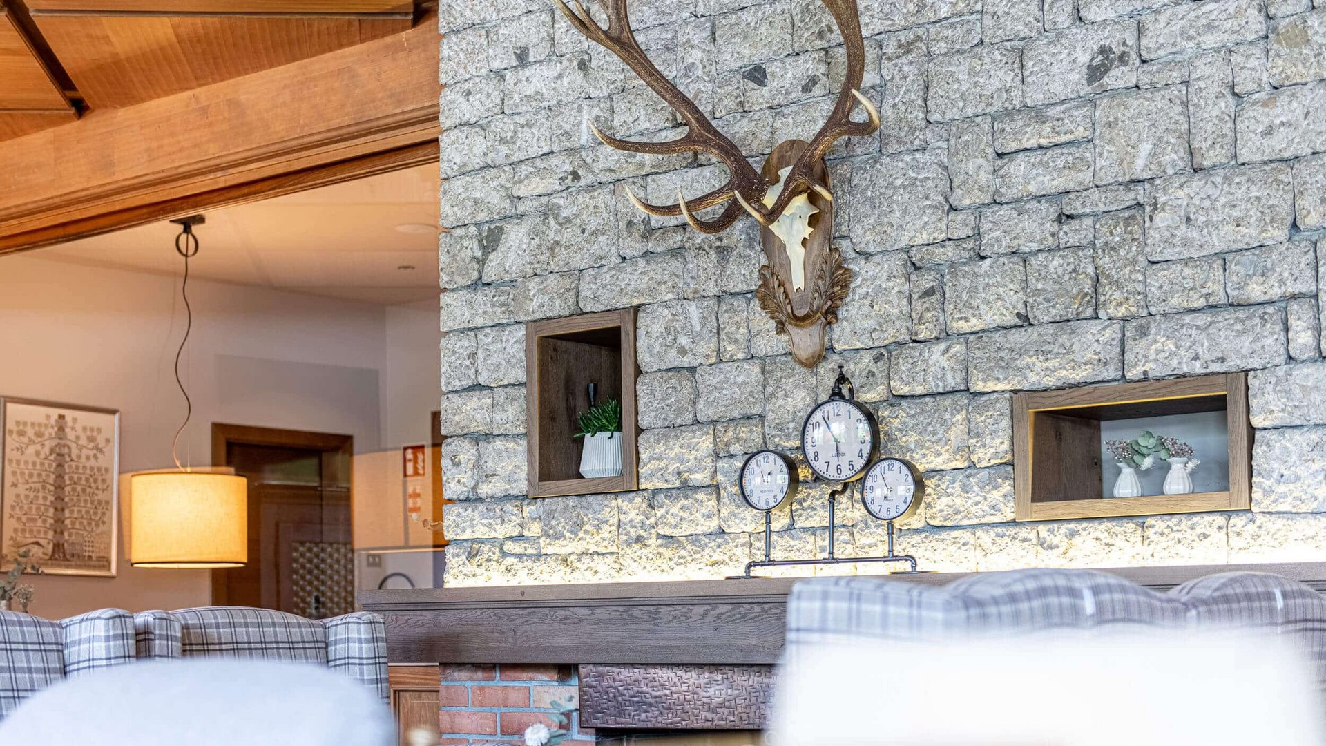 Cozy room with stone wall and mounted deer antlers