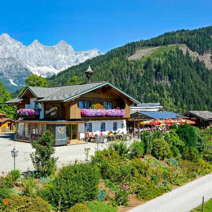 Traditional inn with flower balcony and mountain scenery surrounded by forest