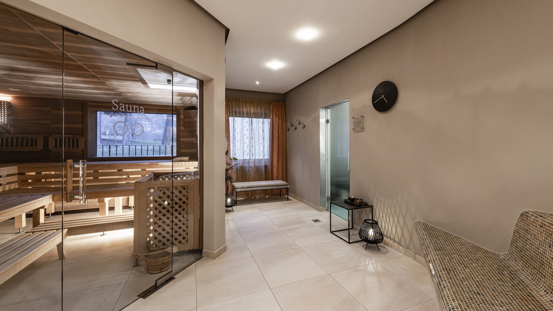 Modern sauna area with glass wall and comfortable seating