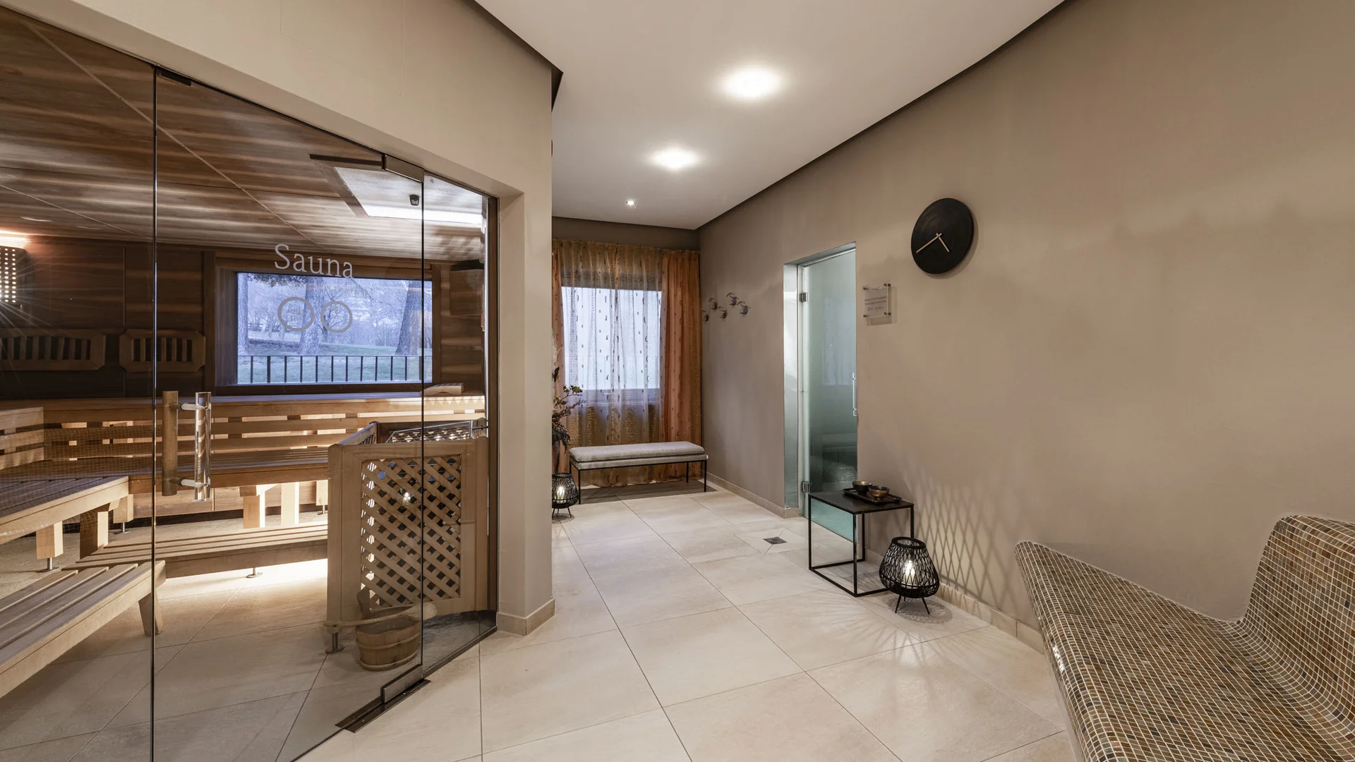 Modern sauna area with glass wall and comfortable seating
