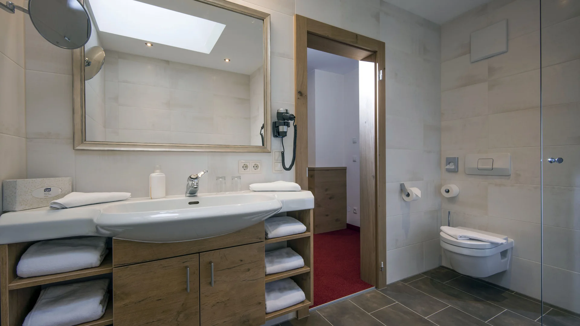 Hotel Andreas Hofer Kufstein **** © Hotel Andreas Hofer Kufstein Modernes Badezimmer mit großem Spiegel, Waschbecken und Toilette
