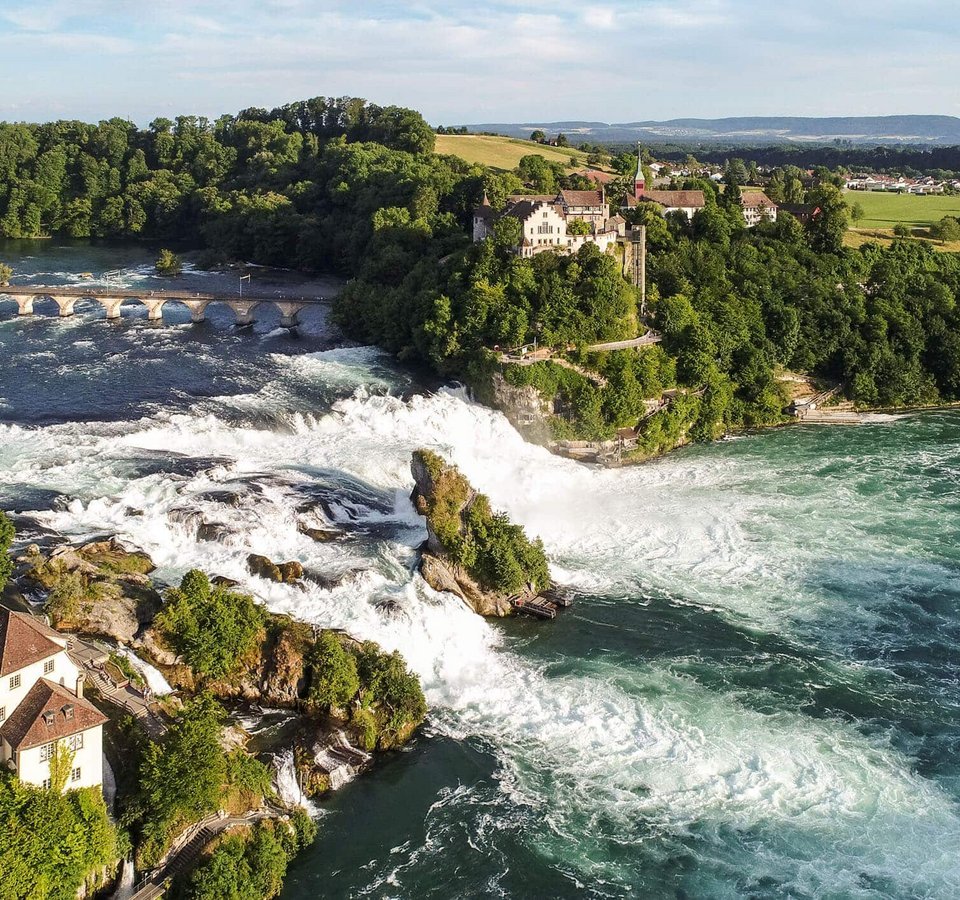 RheinWelten – Eine Reise entlang des Wassers © Schaffhauserland Tourismus - Bruno Sternegg Luftaufnahme des Rheinfalls mit Schloss und Flusslandschaft im Sommer