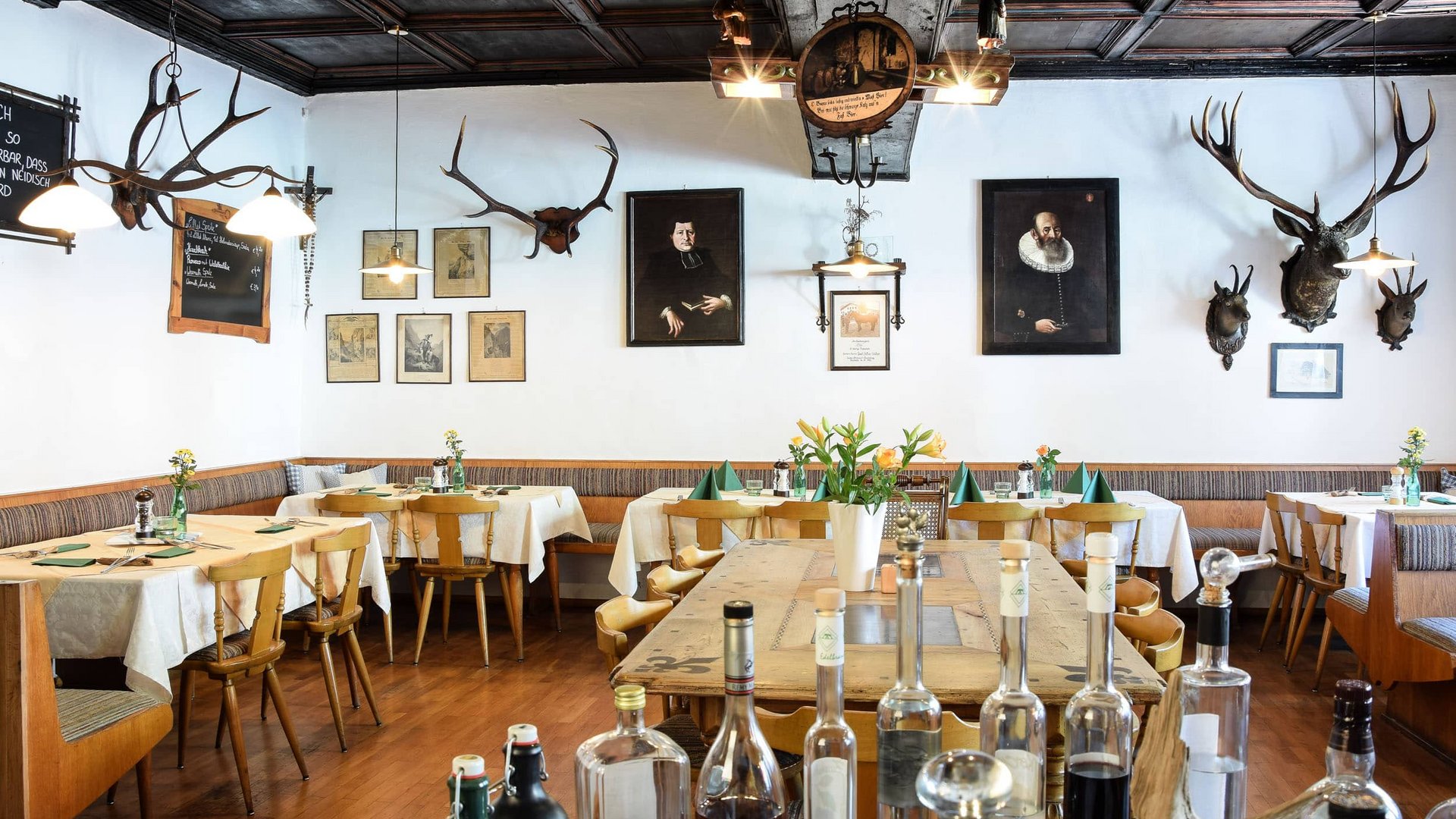 Cozy restaurant with wooden furniture and deer antlers on the walls