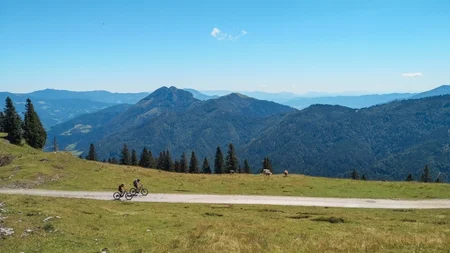Zwei Radfahrer auf einem Weg in den Bergen bei klarem Himmel