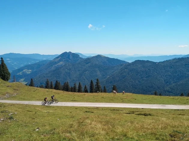 Zwei Radfahrer auf einem Weg in den Bergen bei klarem Himmel