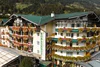 Collective enquiries Hotel with green roofs and colorful flowers on balconies in the mountains
