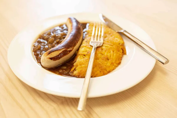 St.Galler Bratwurst © Trägerverein CULINARIUM Bratwurst mit Zwiebelsauce und Kartoffelrösti auf weißem Teller