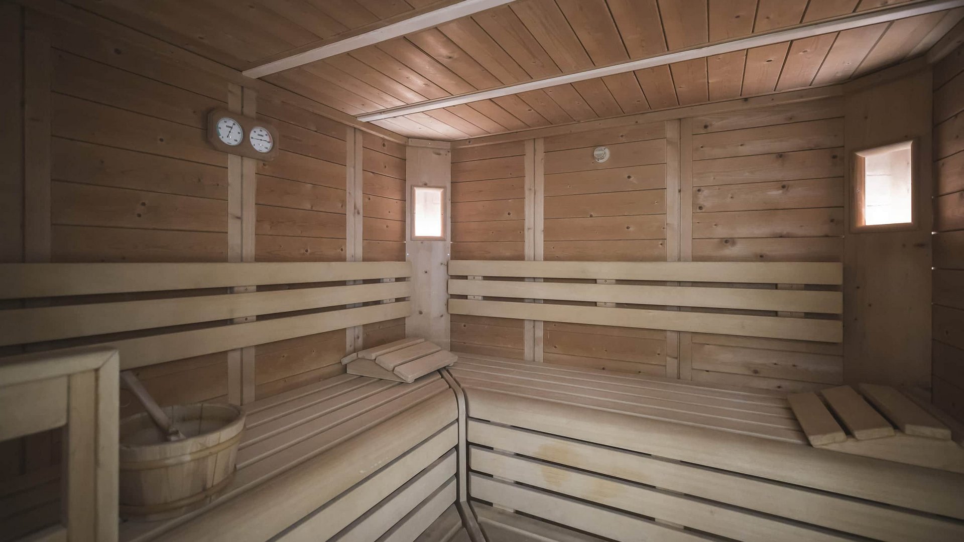 Interior of a traditional wooden sauna with benches and thermometers