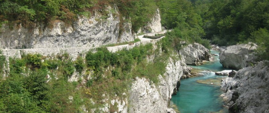 Scenic river with turquoise water flowing between rocky cliffs and lush greenery