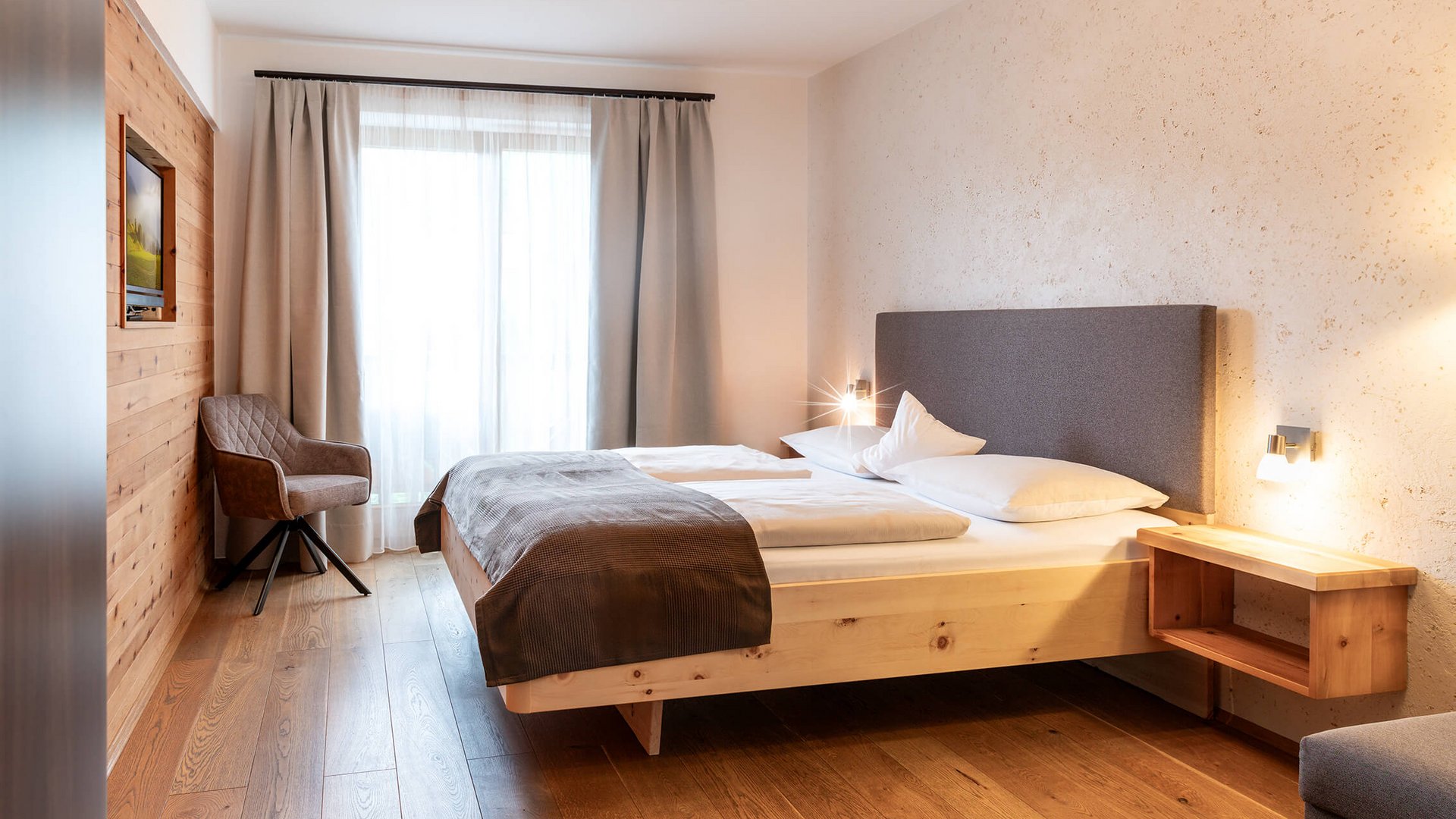 Modern bedroom with bed, chair, and daylight window
