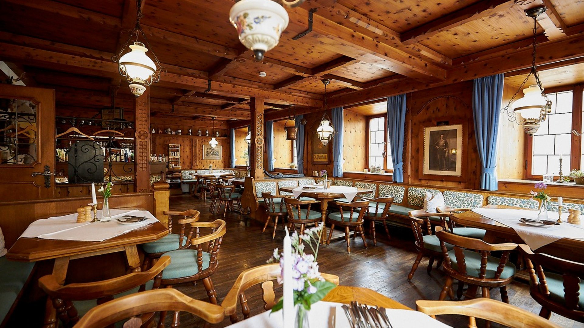 Rustic restaurant with wooden furniture and blue-green chairs