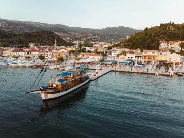 Kultur, Natur und Meer auf Rad- & Schiffsreisen © Kleomenis Koufaliotis Segelboot vor einem belebten Hafen mit Bergen im Hintergrund