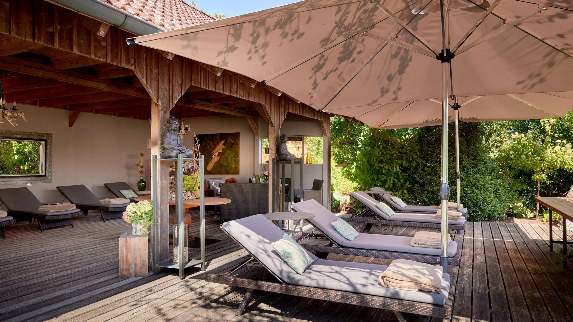 Garden & Spa Hotel das Götzfried **** © Michael Huber Fotographie Ligstoelen met kussens en handdoeken onder grote parasol op houten terras