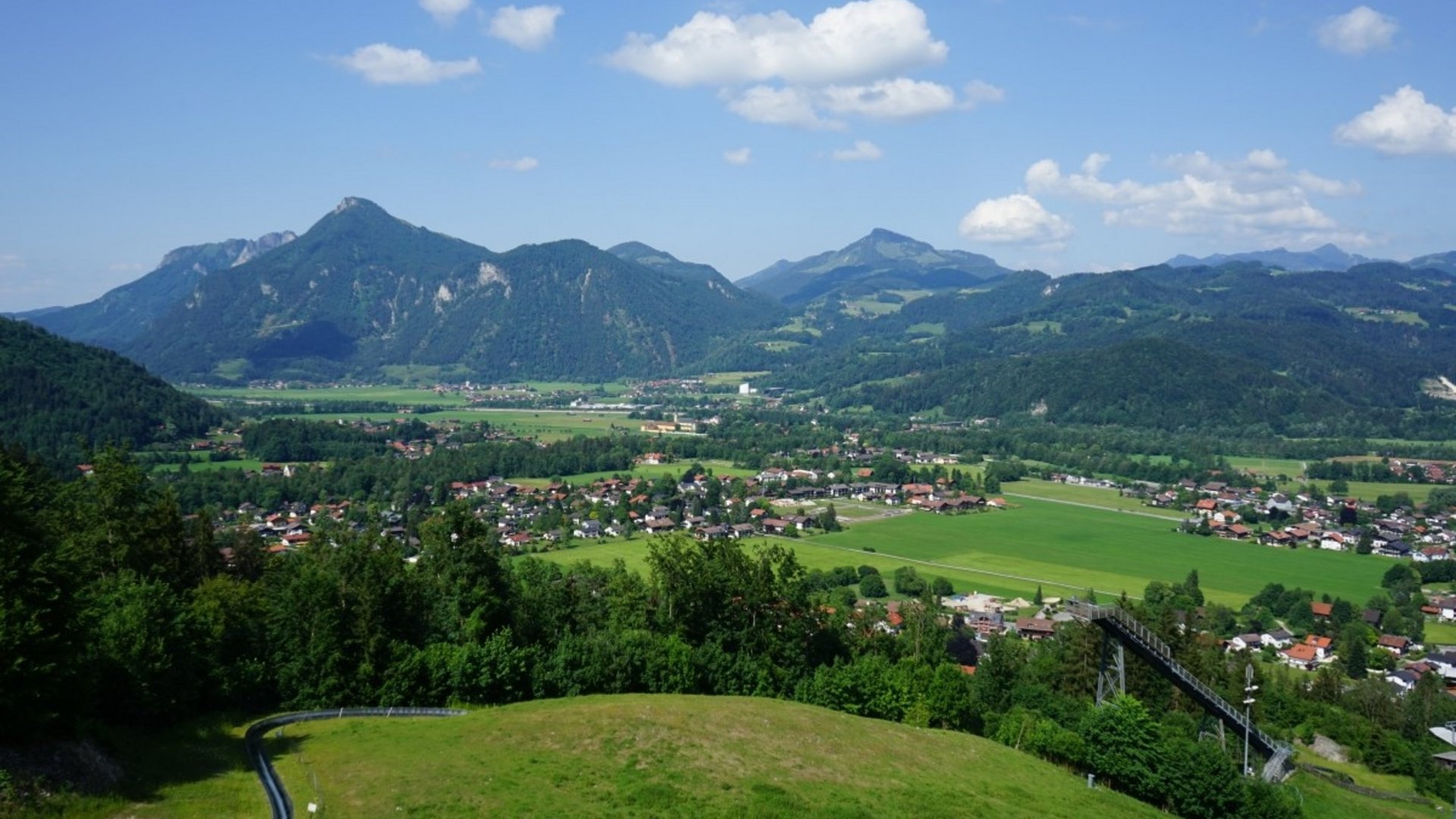 Panoramic mountain view with valley and village under blue sky